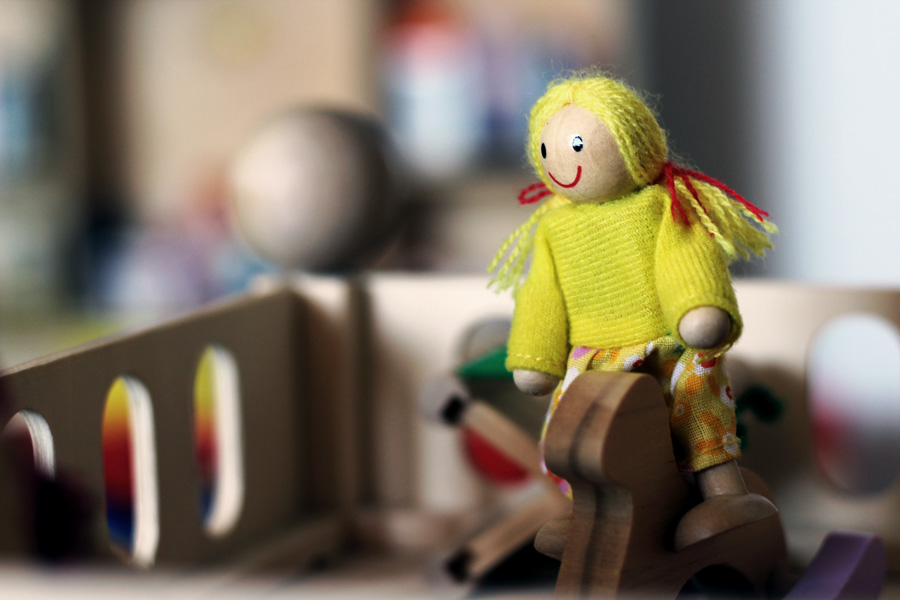 Eine Holzpuppe auf einem kleinen Spielzeugpferd